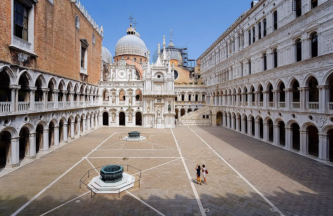 The courtyard of the Doge's Palace with its two bronze well-heads and Renaissance arcades, the domes of St Mark's Basilica rising behind